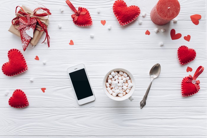 Valentine's Day flat lay with gift, hot chocolate, and smartphone