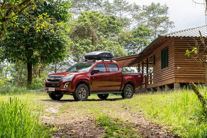 Red Chevrolet D-Max Pickup with Roof Box near Cabin