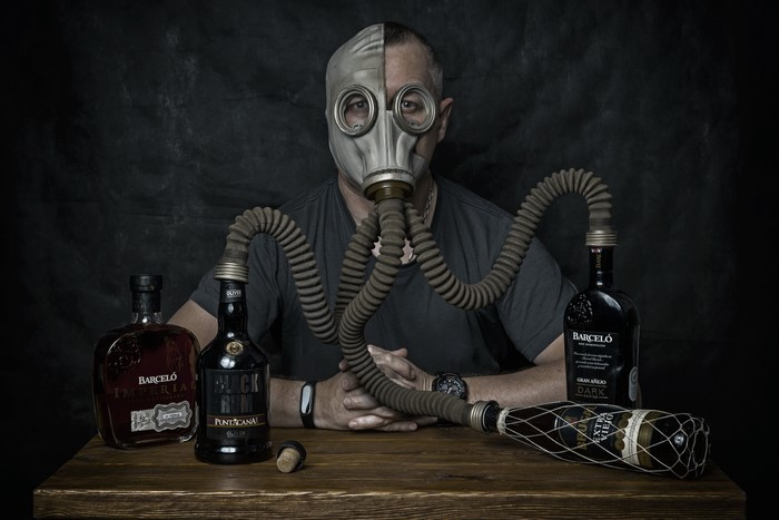 Man in Gas Mask with Barceló Rum Bottles