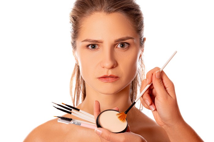 Woman with makeup brushes and powder