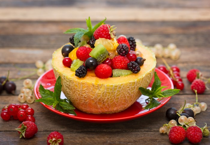 Fruit salad in a melon bowl with berries