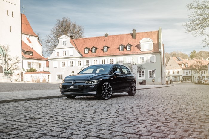 Black ABT Volkswagen Golf on cobblestone street