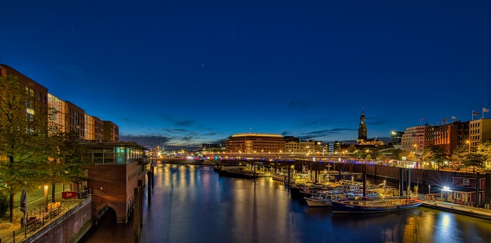 Hamburg harbor at night with boats and buildings