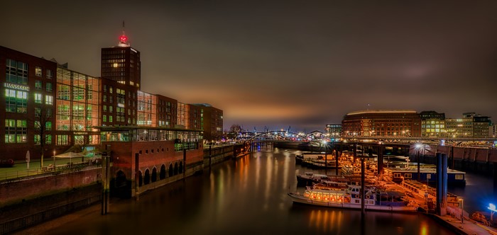 Hamburg harbor at night with illuminated buildings and boats