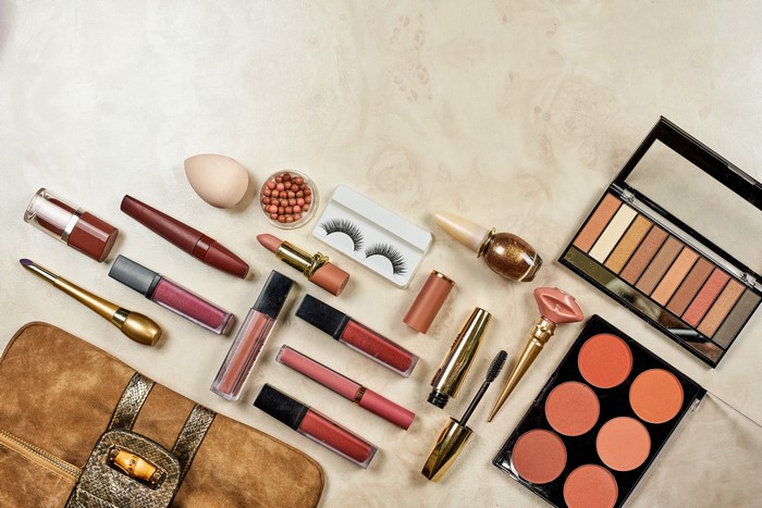Assortment of makeup products on a textured surface