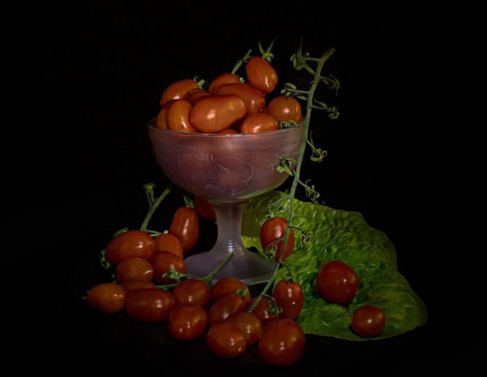 Grape tomatoes in a glass bowl with lettuce
