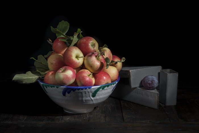 Apples in a bowl with a plum