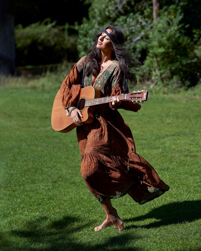 Woman playing guitar in a field