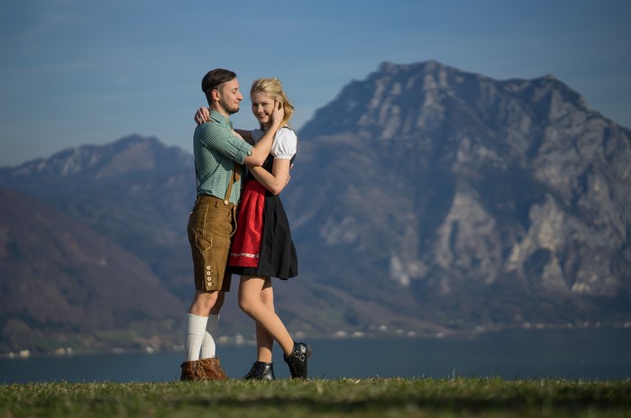 Couple in traditional German attire embracing outdoors