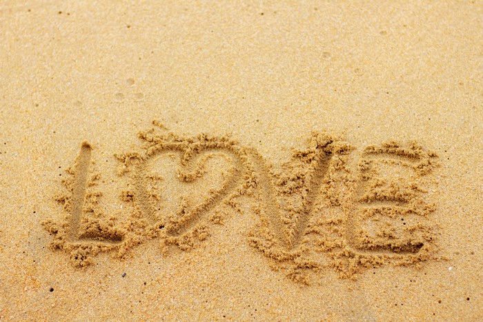 Love written in sand with a heart