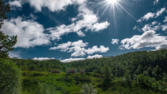 Red cabins in Hjelmeland, Norway under a sunny sky