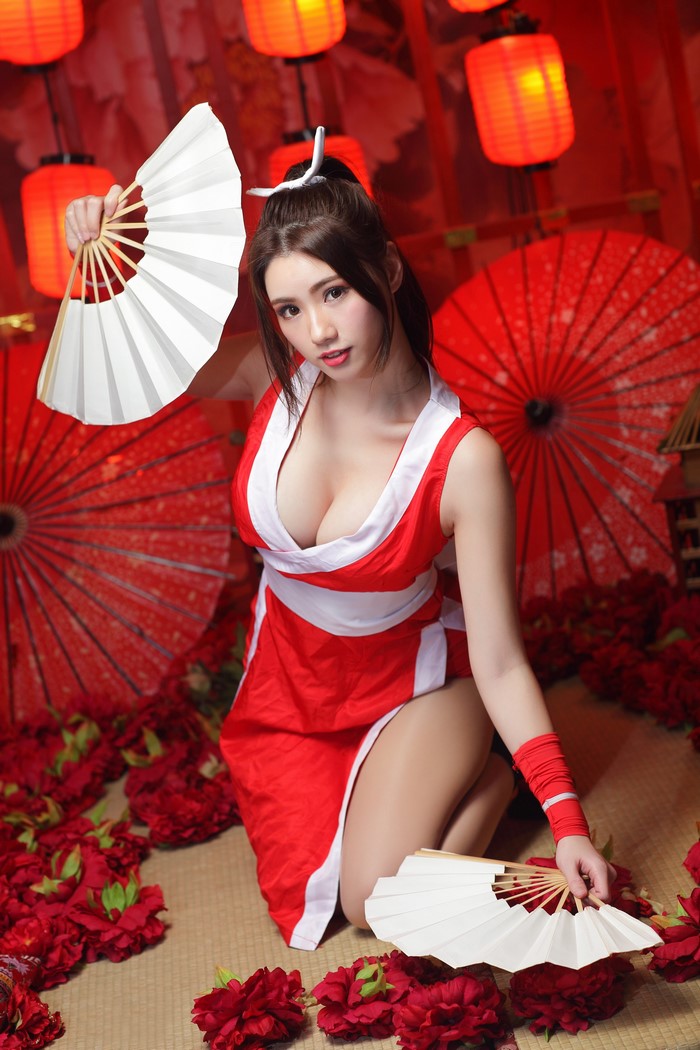 Asian woman in red dress holding fans