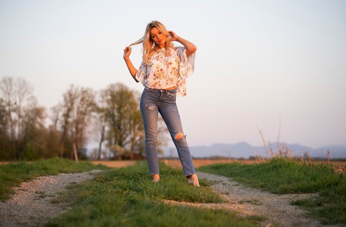 Blonde girl in jeans and blouse posing