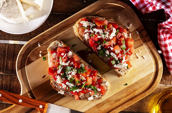 Bruschetta with tomatoes and cheese on a cutting board
