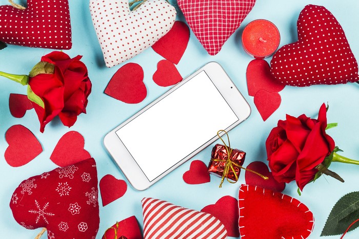 Smartphone surrounded by Valentine's Day decorations
