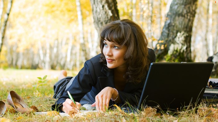 Woman working on a laptop in autumn