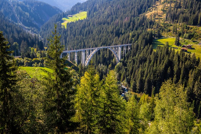 Arch bridge over a forest valley in Switzerland