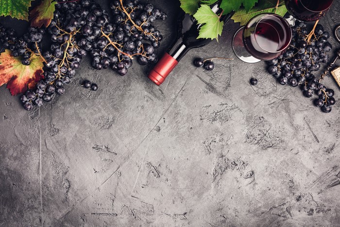 Grapes and red wine bottle with glass