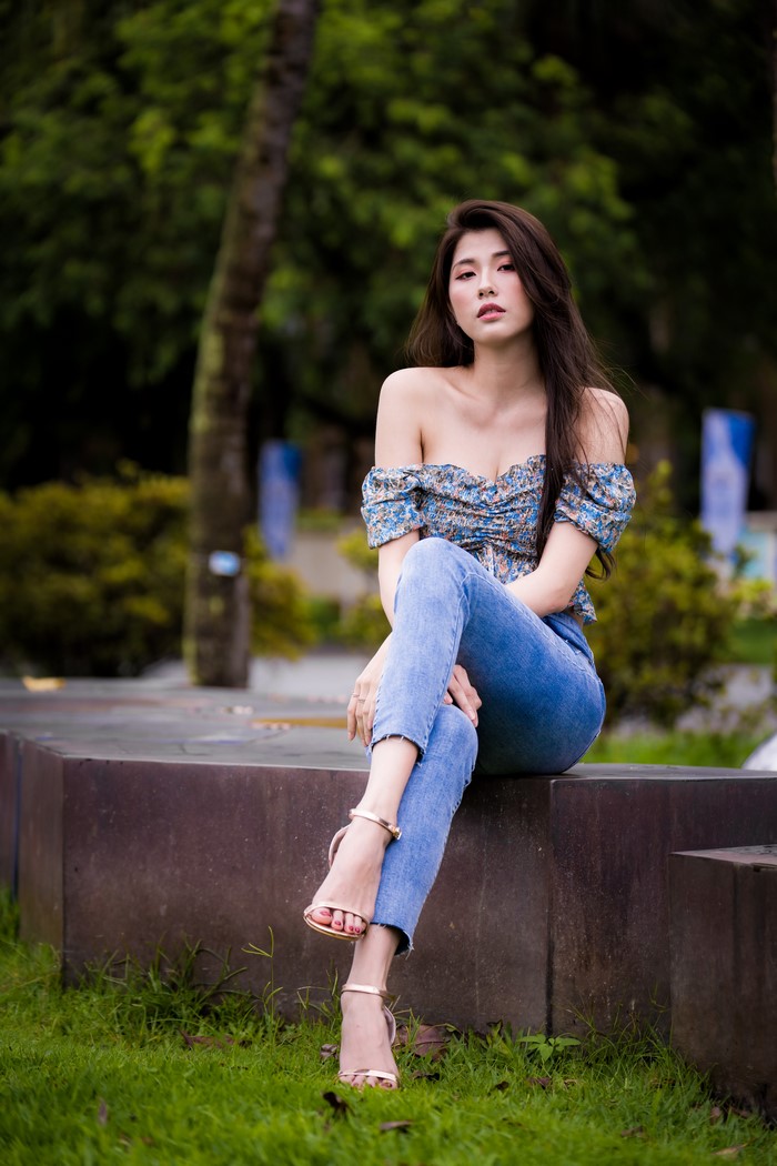 Asian woman sitting in jeans and blouse