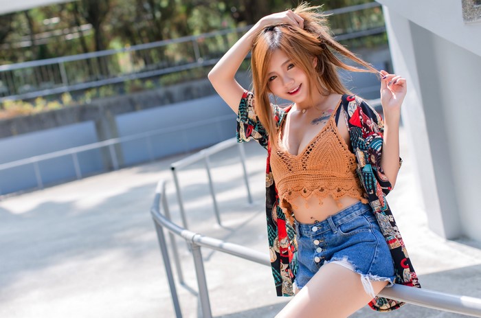 Asian woman in crochet top and denim shorts