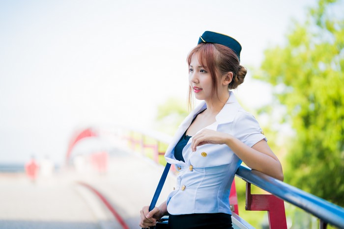 Asian woman in stewardess uniform on a bridge