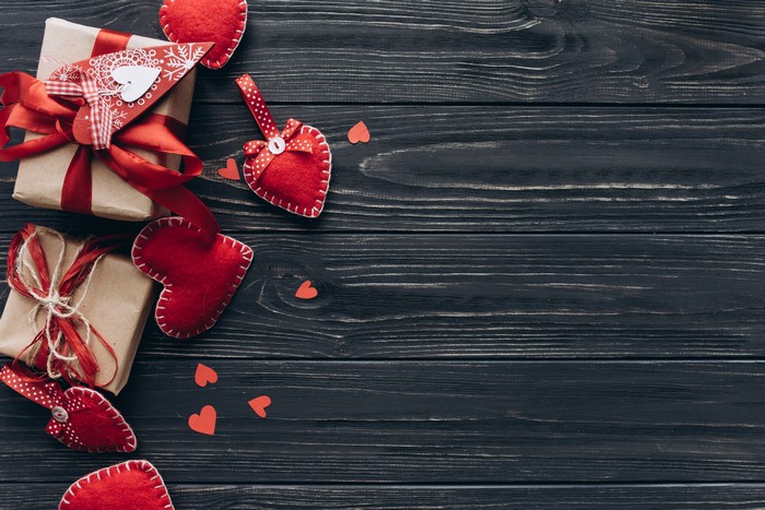 Valentine's Day gifts and hearts on a dark wooden background