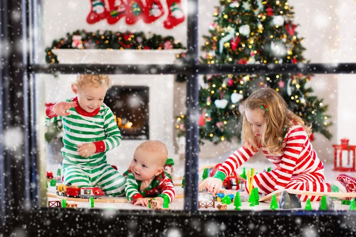 Children playing with toy train on Christmas morning