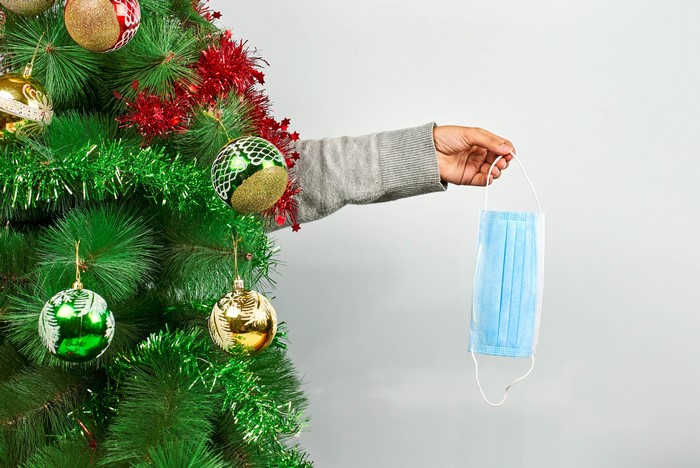Christmas tree with a hand holding a mask