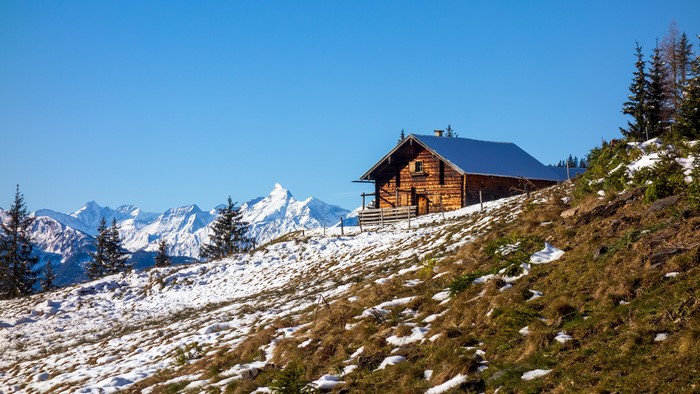 Wooden cabin on snowy mountain slope, Alps, Austria