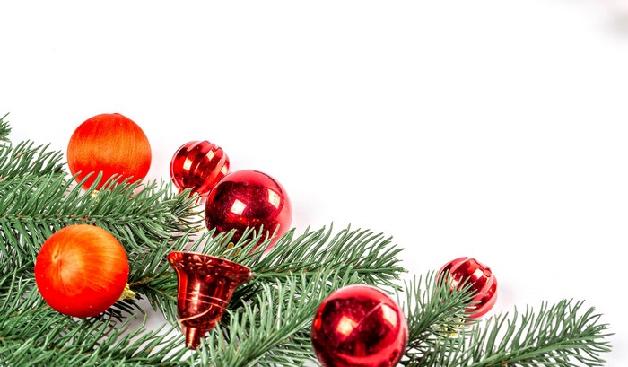 Christmas tree branches with red ornaments and bells