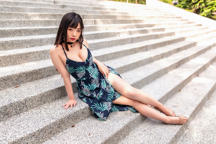Asian woman in dress sitting on stairs
