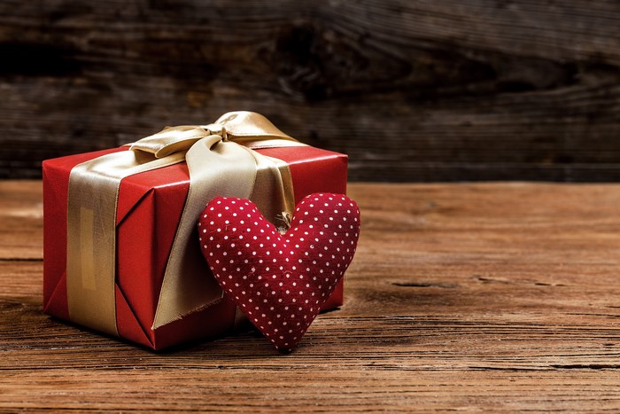 Red gift box with golden ribbon and polka dot heart
