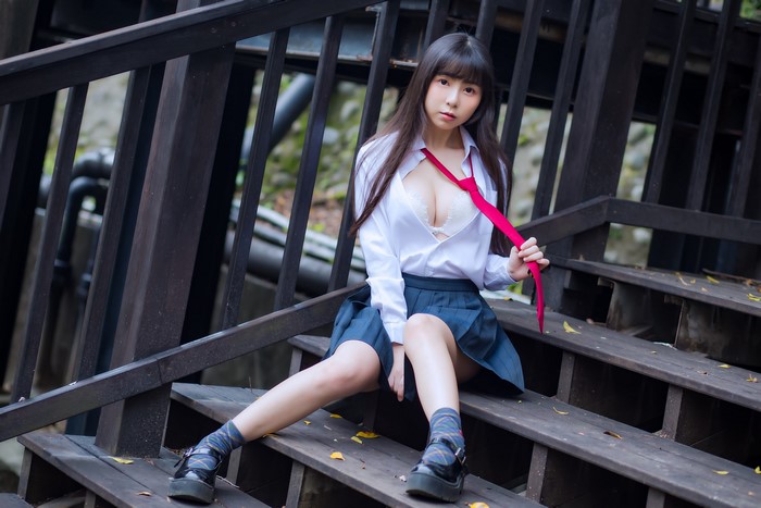 Asian girl in school uniform sitting on stairs