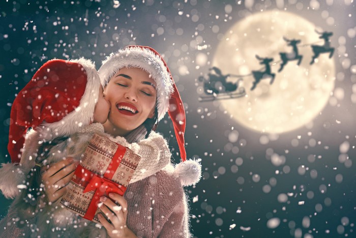 Mother and child in Santa hats with Christmas gift
