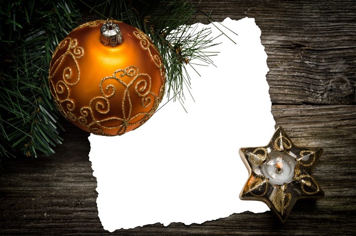 Christmas ornament and candle on wood planks