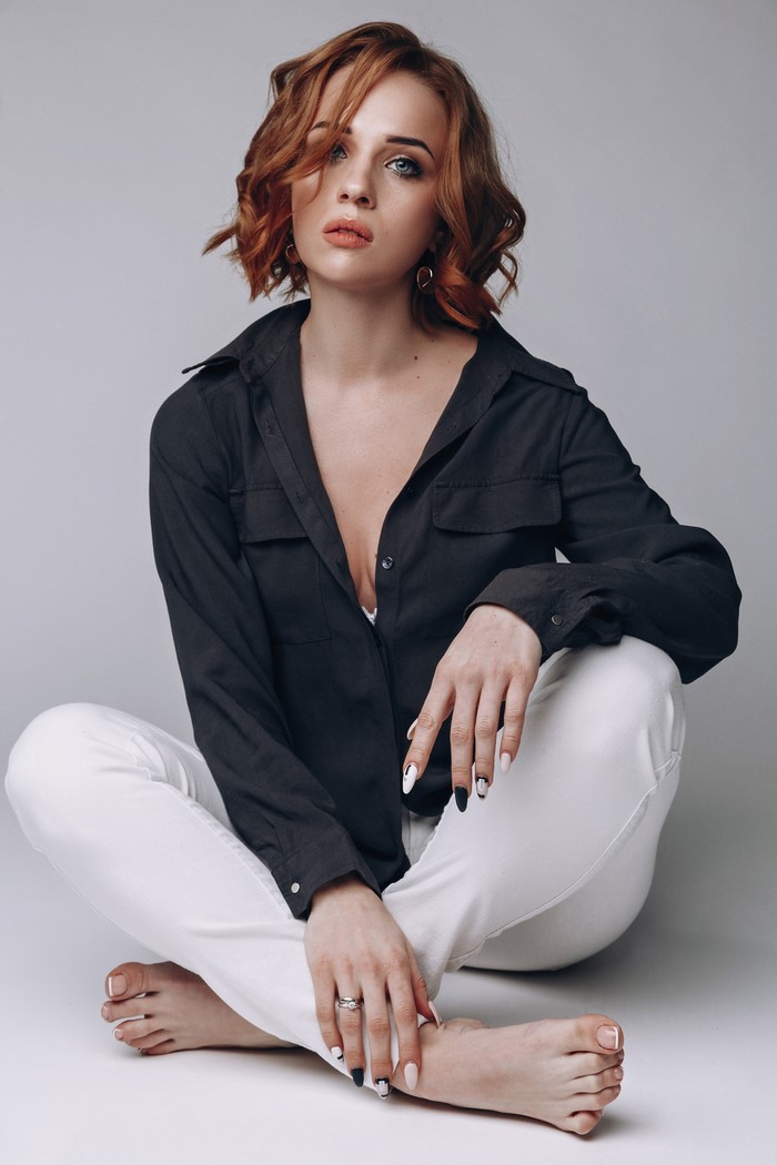 Redhead woman in black shirt and white pants