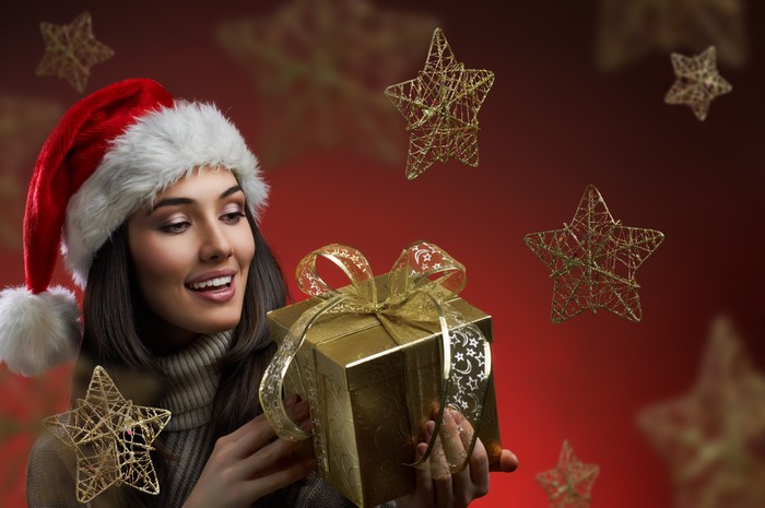 Woman in Santa hat holding a Christmas gift