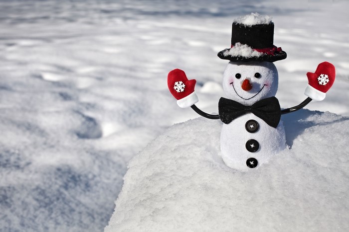 Snowman with hat, bow tie, and mittens in snow