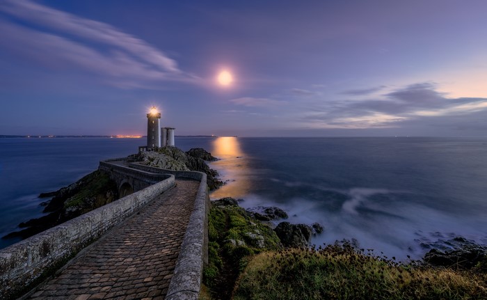 Lighthouse on a rocky coast in Brittany, France at night