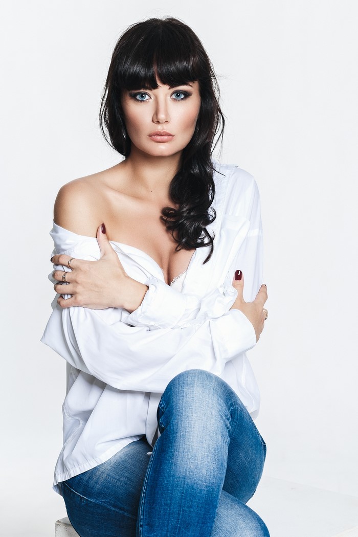 Brunette woman in jeans and white blouse