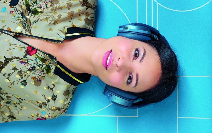Brunette girl with Focal Listen Wireless headphones lying down