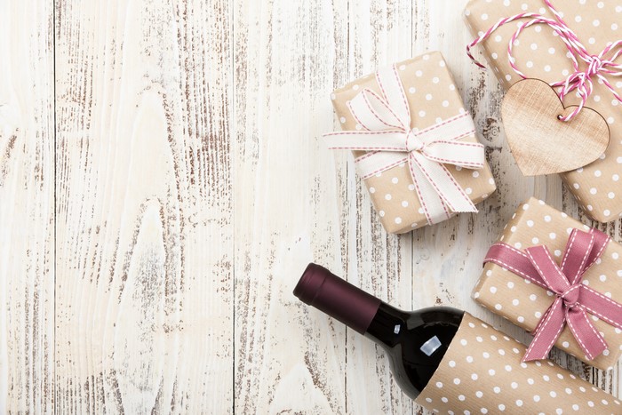 Gifts and Wine Bottle on Wooden Table