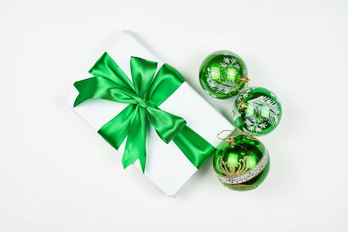 White gift with green bow and Christmas ornaments