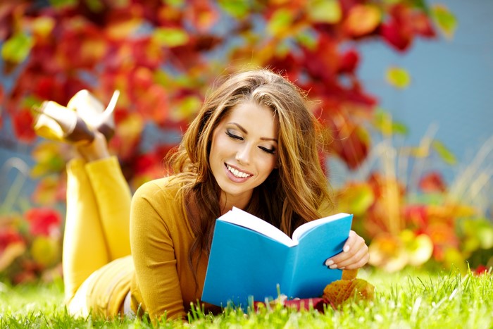 Woman reading a book in autumn