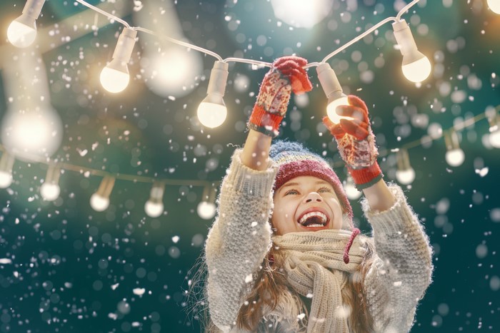 Girl hanging Christmas fairy lights