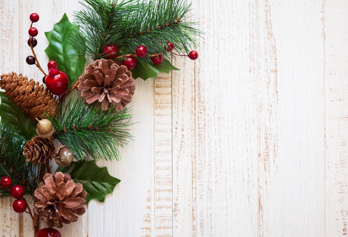 Christmas decoration with pine cones and berries on wood