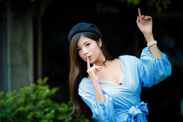 Asian woman wearing a beret and blue dress