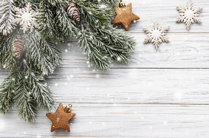 Christmas branches with snowflakes and star decorations on wood