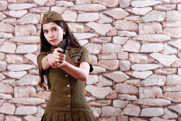 Woman in police uniform holding a pistol