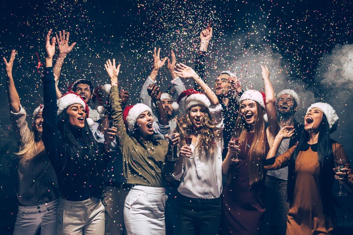 Group of people celebrating with confetti and Santa hats
